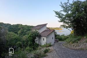 a small white house on the side of a road at Affordable Island Villa with Sea Views Great Value Stay in Bizen