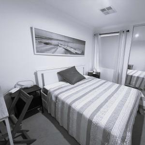 ein weißes Schlafzimmer mit einem Bett und einem Fenster in der Unterkunft 42 Coogee Beach Marina 3br Haven Near Omeo Wreck in Spearwood