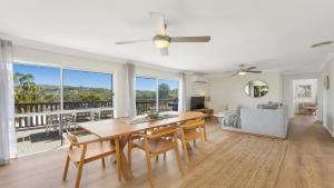 a living room with a dining room table and a couch at Jean's Beach House Accom Holidays in Copacabana