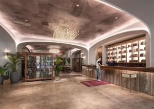 a lobby with a woman standing at a counter at Mercure Hotel in Xi'an