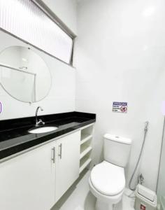 een badkamer met een toilet, een wastafel en een spiegel bij Elizondo Pousada Dr Freitas in Belém