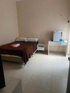 een slaapkamer met een bed en een laptop op een tafel bij Elizondo Pousada Dr Freitas in Belém