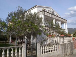 a white house with a fence in front of it at Apartment in Pridraga - Zadar Riviera 7998 in Pridraga
