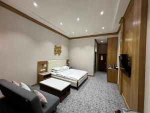 a hotel room with a bed and a couch at Hotel Elegant in Andizhan