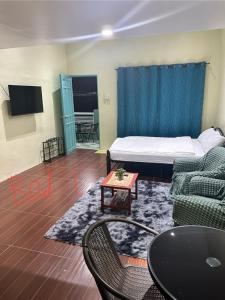 een kamer met een bed, een bank en een tafel bij SJ Vistacation in Tanza