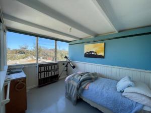 een slaapkamer met een bed in een kamer met ramen bij Balclutha in Point Lonsdale