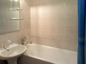 ein Badezimmer mit einem Waschbecken, einer Badewanne und einem Waschbecken in der Unterkunft Central Park Apartment in Dnipro