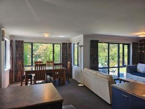 a living room with a couch and a table at Fisherman's Friend - a spacious family beach home in Pohara
