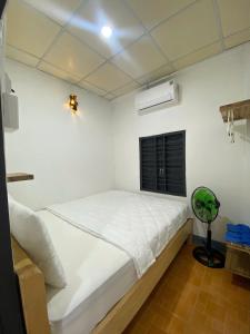 a bedroom with a white bed and a window at Homestay Nhà Của Gạo in Ấp Thiẹn Ái