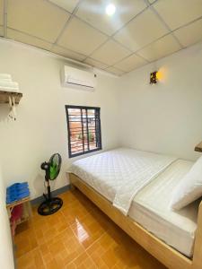 a bedroom with a bed and a window at Homestay Nhà Của Gạo in Ấp Thiẹn Ái
