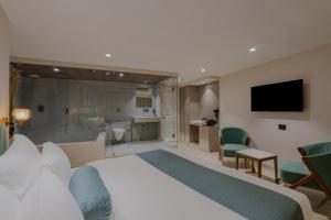 a hotel room with a large bed and a bathroom at Hotel The Grand Suites in Ahmedabad