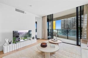 a living room with a couch and a table at Luxurious 2-Bed Designer Retreat at Oracle Resort in Gold Coast