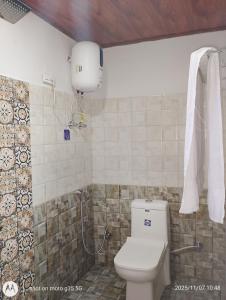 een badkamer met een toilet en een watertank bij Mountain Paradise Homestay BATASIA LOOP in Darjeeling