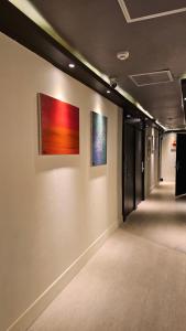 a hallway with two paintings on the wall at 더 갤러리 호텔 in Suwŏn-yŏk