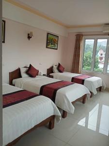 - un groupe de trois lits dans une chambre dans l'établissement Khách Sạn Thành Loan 2, à Nà Phia