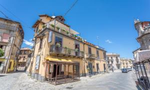 a yellow building with a balcony on a street at Hotel Conte Ruggero in Serra San Bruno