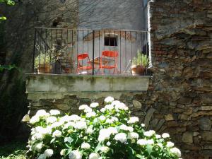 dwa czerwone krzesła siedzące na balkonie z kwiatami w obiekcie Appartamenti a Magnano w mieście Magnano