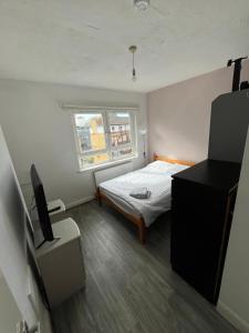 a small room with a bed and a television at Minimalist 2BR Duplex Near The Shard in London
