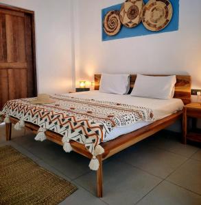 a large bed with a wooden frame in a room at Paje Beach Zanzibar Private Luxury Villa with pool AC WIFI TV 90m walk to beach central location walk to shops bars & restaurants in Paje