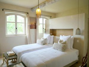 two beds in a room with two windows at Stunning Stone House With Pool Near Gordes in Gordes +24 photos