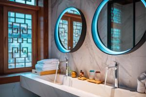 a bathroom with two mirrors and a sink at Sanctum Peaks in Zhangjiajie