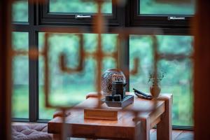 a table with a coffee maker on it in front of a window at Sanctum Peaks in Zhangjiajie