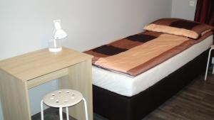 a small bedroom with a bed and a desk at Hostel Kamienna Centrum in Katowice