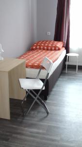 um quarto com uma cama, uma cadeira e uma secretária em Hostel Kamienna Centrum em Katowice