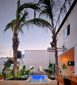 a swimming pool with two palm trees next to a building at Paje Beach Zanzibar Private Luxury Villa with pool AC WIFI TV 90m walk to beach central location walk to shops bars & restaurants in Paje +28 photos