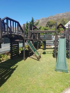 Un parque infantil de madera con tobogán y columpios en 4Th On Boundary, en Gordonʼs Bay