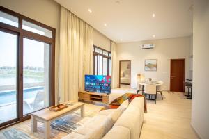 a living room with a couch and a tv at Villa AZ - Hawana Salalah in Salalah