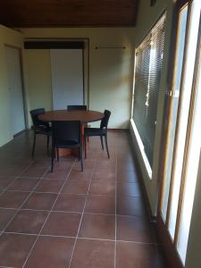 Un comedor con mesa y sillas y ventanas. en 4Th On Boundary, en Gordonʼs Bay