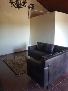 Una sala de estar con un sofá de cuero y una alfombra. en 4Th On Boundary, en Gordonʼs Bay