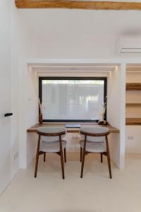 zwei Tische und zwei Stühle in einem Raum mit einem Fenster in der Unterkunft Hoshi Villas in General Luna