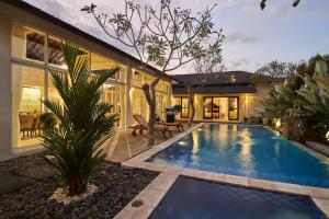 a swimming pool in the backyard of a house at Villa Umasari Keramas in Keramas