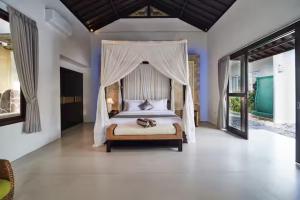 a bedroom with a bed with a canopy at Villa Umasari Keramas in Keramas +16 photos