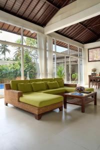a living room with a green couch and a table at Villa Umasari Keramas in Keramas