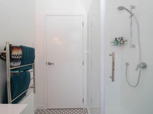 新普利茅斯Blue Water Cottage - with beachfront coastal views的带玻璃门淋浴间的浴室