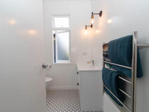 新普利茅斯Blue Water Cottage - with beachfront coastal views的带水槽和马桶的白色浴室