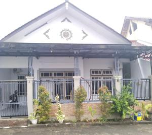 a house with a porch and a fence at Grities 7 Home Jogja in Yogyakarta +3 photos