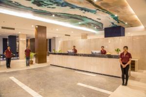 une femme debout devant un comptoir dans un hall dans l'établissement Hotel Lumbini Heritage, à Rummindei