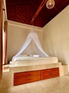 a bed with a white canopy in a room at Sumatra Expedition Lodge in Bukit Lawang