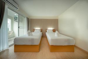 two beds in a hotel room with at The Nook Hotel in Chiang Mai +23 photos