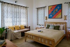 a bedroom with a bed and a couch in it at Okka by Raho - A colonial style villa in Coorg in Siddapur +64 photos