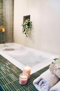 a bathroom with a candle and towels and a bath tub at Okka by Raho - A colonial style villa in Coorg in Siddapur