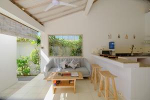 a living room with a couch and a table at Villa Beji Ayu Seminyak - 2 Bedroom Private Pool in Seminyak