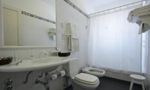 a white bathroom with a sink and a toilet at Solar De La Plaza in Salta