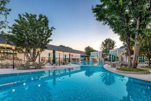een zwembad in een resort met stoelen en bomen bij InterContinental Maotai Town in Renhuai