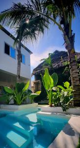 a swimming pool with palm trees and a house at Waterfall Villa Paje Beach Zanzibar your tropical paradise awaits! in Paje