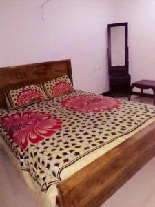a bedroom with a bed with red flowers on it at Chapa Resting Place in Dickwella